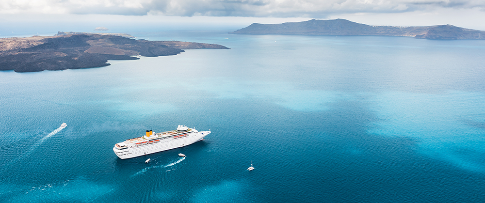 Beautiful landscape with sea view. Cruise liner at the sea near the islands. Santorini island, Greece.